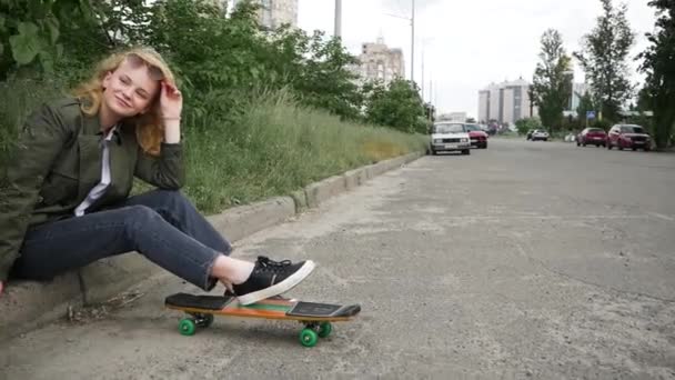 Tonårstjej Med Skateboard Sitter Trottoarkanten — Stockvideo