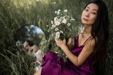 Papatya tarlasını seven güzel bir kadın, çayırda dinlenen güzel bir Asyalı kadın.