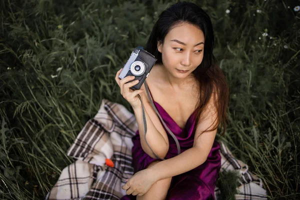 美しいアジアの女性がグリーンフィールドで古いヴィンテージカメラを開催 — ストック写真