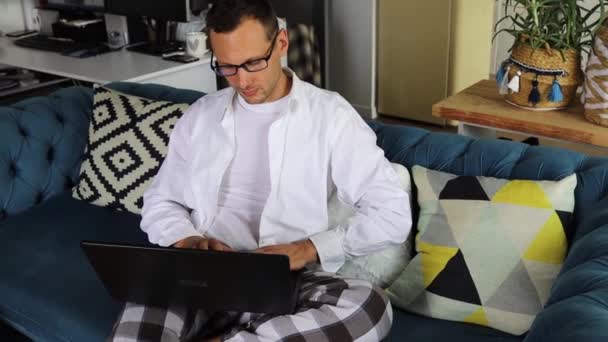 Knappe Man Freelancer Met Behulp Van Laptop Zitten Bank Thuis — Stockvideo