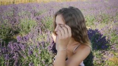 Genç güzel sarışın kadın yaz günü lavanta tarlasında dinleniyor.