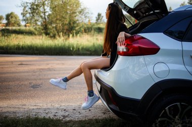 Gün batımında SUV Aracında oturan Güzel Kadın