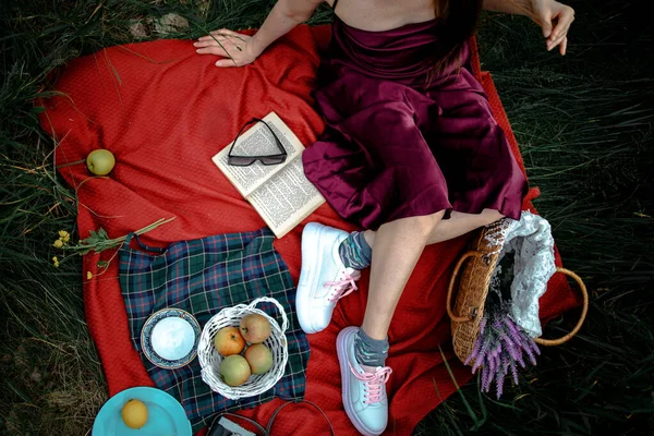 妇女躺在公园的室外 带着野餐篮吃苹果 — 图库照片