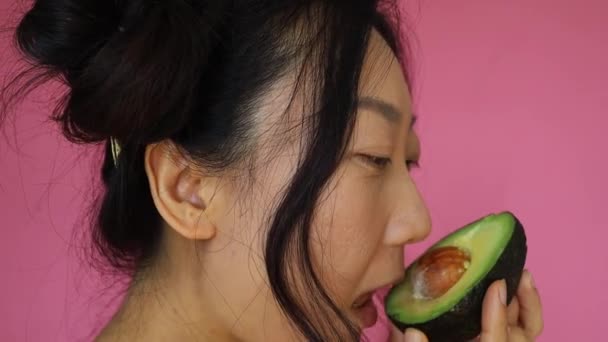 Sexy Asian Woman Licking Avocado Half Pink Background — Wideo stockowe