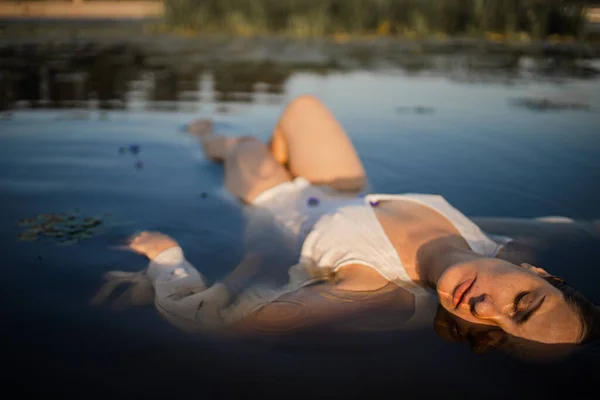 躺在水里的年轻女子的神秘而时尚的画像 — 图库照片