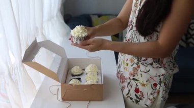 Hand Of Brunette Girl Showing Cupcake From Gift Box