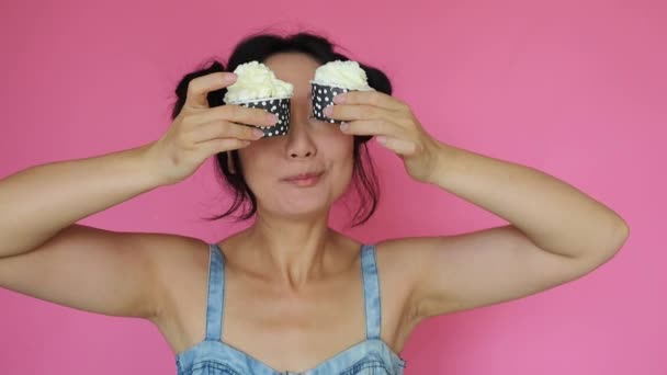 Funny Asian Girl Holds Cupcake Cream Pink Background — Vídeo de stock