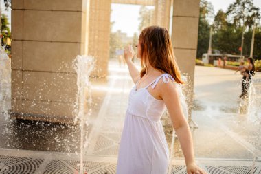 Sıcak bir yaz gününde serin su pınarında oynayan genç kız
