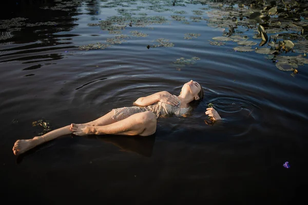 躺在水里的年轻女子的神秘而时尚的画像 — 图库照片