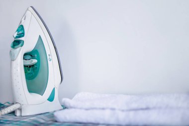 Ev çamaşırları ütülüyor. Beyaz arkaplanda ütü, Boşluğu Kopyala.