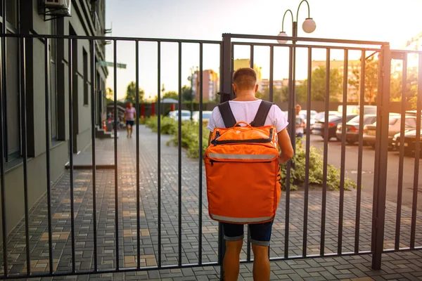 Giovane Fattorino Che Cammina Con Borsa Termica Arancione Sulla Strada — Foto Stock