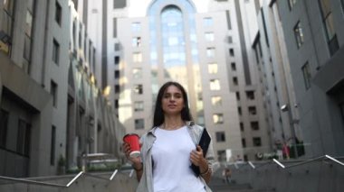 Yüksek teknoloji iş binasının yanında tableti olan mutlu, güzel bir kadın. Kahvesini fincana koyup yaz sıcağının tadını çıkarıyor. Metin için boşluk