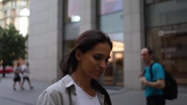 Tişört giyen, cep telefonu kullanan, cep telefonlu, cep telefonlu, cep telefonlu, cep telefonlu, cep telefonlu gülümseyen bir kadın.