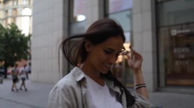 Tişört giyen, cep telefonu kullanan, cep telefonlu, cep telefonlu, cep telefonlu, cep telefonlu, cep telefonlu gülümseyen bir kadın.