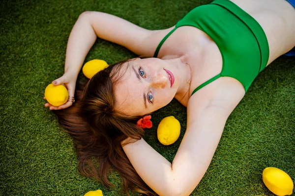 Рыжая Женщина Веснушками Летом Лежит Траве Желтыми Лимонами — стоковое фото