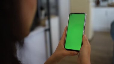 El kamerası: Esmer Kadın 'ın Krom Anahtar Tutan Yeşil Ekran Telefonu Dokunmadan ve Çalkalamadan İzleme İçeriği. Kız Cep Telefonu Kullanıyor, İnternet Taranıyor, İçerik İzleniyor