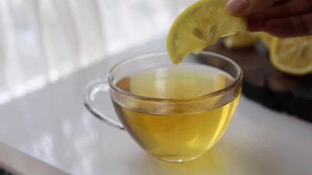 Χέρι Συμπιέζει Χυμό Λεμονιού Ένα Φλιτζάνι Τσάι — Αρχείο Βίντεο