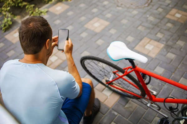 Young Man With A Bike In The City, Using Smartphone