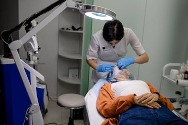 Bir sağlık merkezinde lazer ve ultrason tedavisi gören bir kadın.