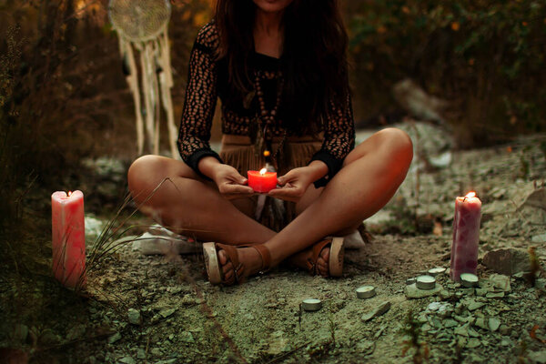 Asian woman with candles deep in the forest. Witchcraft concept