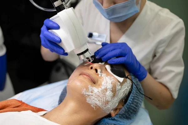 Asian Woman receiving laser and ultrasound facial treatment in a health resort center