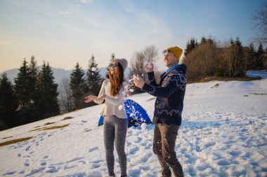 Genç melez çift kış tatilinde karda eğleniyor.