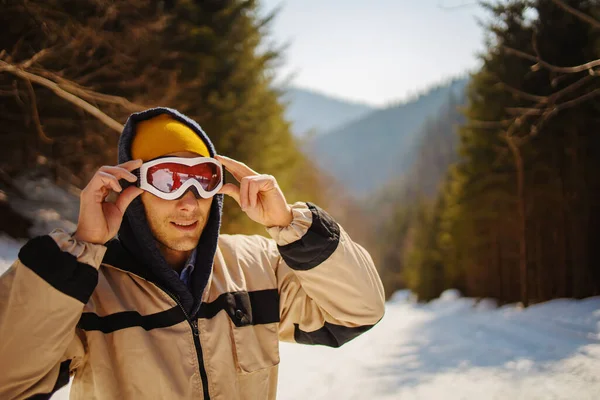 Молодой Человек Лыжами Снежном Лесу Стоит Вершине Холма — стоковое фото