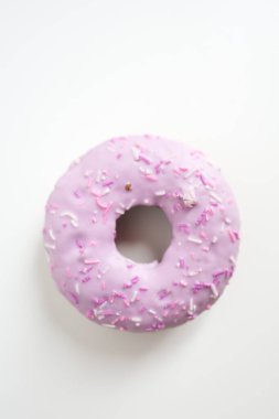 Pembe kremalı ve rengarenk şekerli donut. Çilekli, garnitürlü çörek. Beyaz arka planda pembe çörek yakın plan. Renkli serpiştirilmiş Pembe Renkli Donut Lezzetli bir ikram