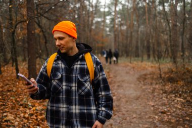 Yağmurlu bir günde sonbahar ormanlarında akıllı telefonlu mutlu Kafkas yürüyüşçüleri..