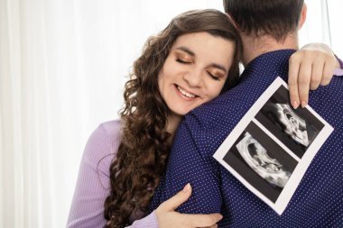 Hamile çift gelecekteki bebeklerinin ultrason taramasını tutuyor. Bir bebek bekliyorum..