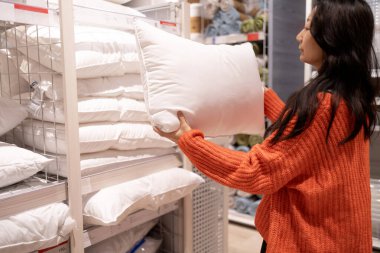 Alışveriş kavramları. Asyalı kadınlar yatak bölümündeki yastıklara bakmayı tercih ediyor..