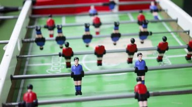 Masa futbolu. Başlangıç maçında topa odaklan. Masa futbolunun ayrıntıları. Masa futbolu: oyuncular yakın planda görünür. Yetişkinler ve çocuklar için futbolda masa oyunu.