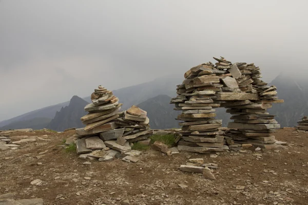 Pocas piedras planas apiladas pirámide sobre una montaña en el fondo — Foto de Stock