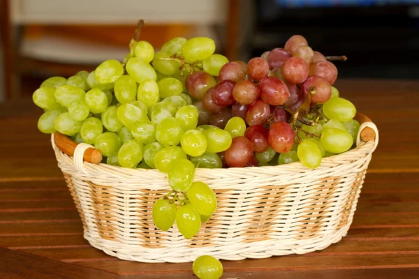 Green and red grapes in the wicker basket. — Stock Photo, Image