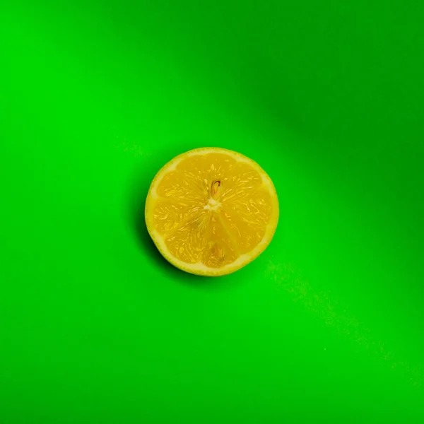 Slice of lemon shot on a green background — Stock Photo, Image