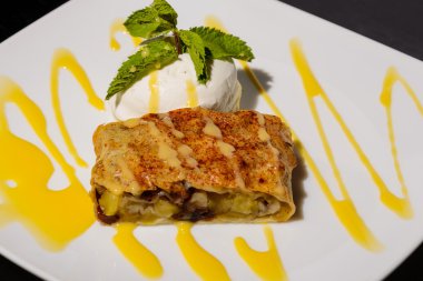 Beyaz bir tepside pudra şekeri serpilir Apple strudel.