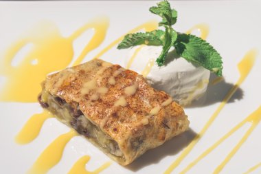 Beyaz bir tepside pudra şekeri serpilir Apple strudel.