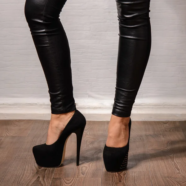 Slanke vrouwelijke benen in donkere hoge hakken — Stockfoto