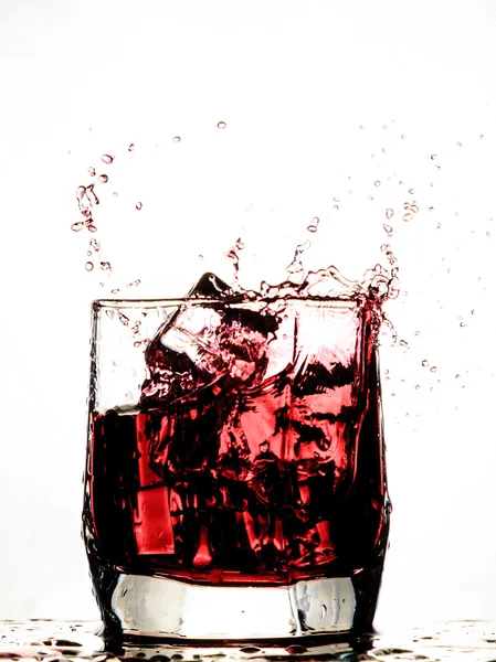 Крижаний куб бризкає в прохолодному склянці води — стокове фото