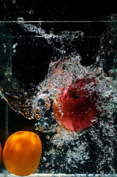 Orange dropped in fish tank filled with water — Stock Photo, Image