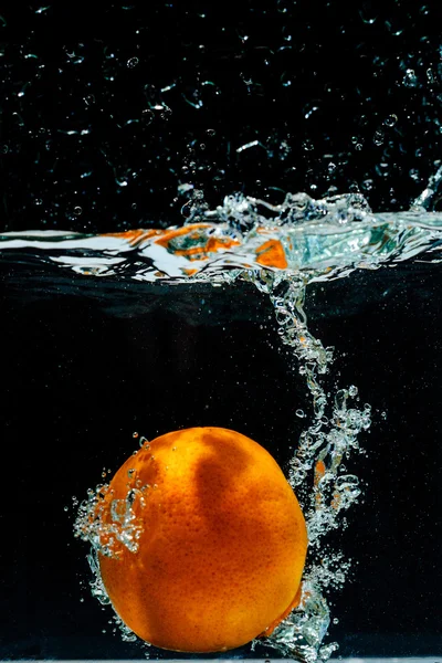 Fotografía de alta velocidad de naranja con salpicaduras en el agua — Foto de Stock