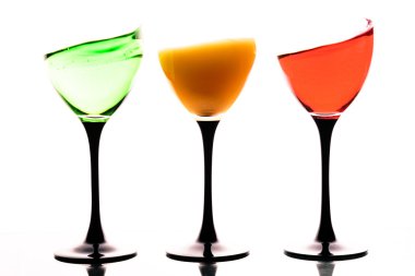 Beyaz bir arka plan üzerinde renkli sıvılar ile Üç ayaklı büyük kadehler