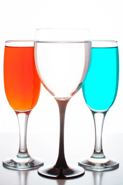 Three glasses of wine with colored liquids — Stock Photo, Image