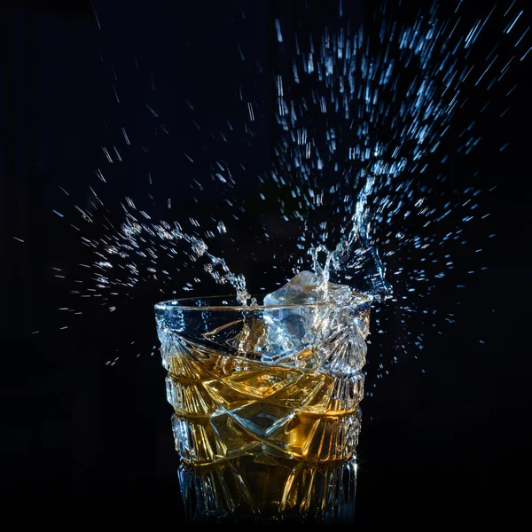 Spruzzi di whisky dai cubetti di ghiaccio che cadono — Foto Stock