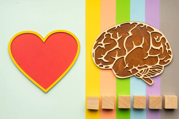Mock up of the human brain and heart on a colorful background. Six cubes in which you can write the word autism in your font.