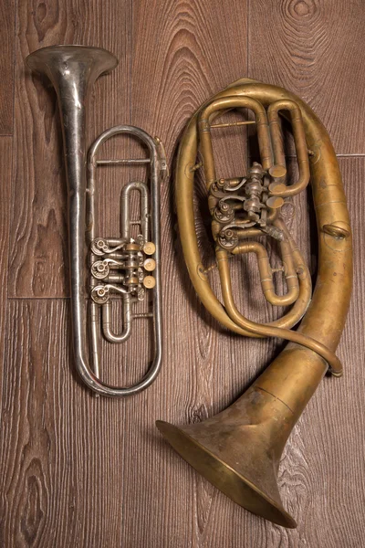 Altes Blechblasinstrument und Horn auf einem hölzernen Hintergrund — Stockfoto