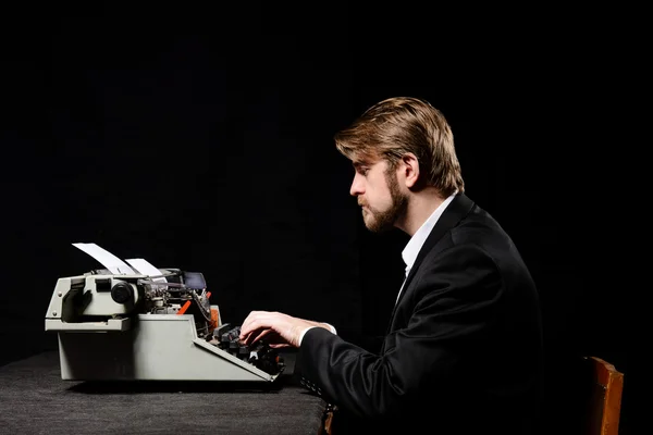 Συγγραφέας, άνθρωπος σε ένα μαύρο σακάκι πληκτρολογώντας σε γραφομηχανή — Φωτογραφία Αρχείου