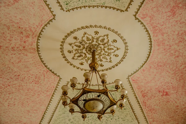 Lustre pendurado sob um teto no palácio — Fotografia de Stock