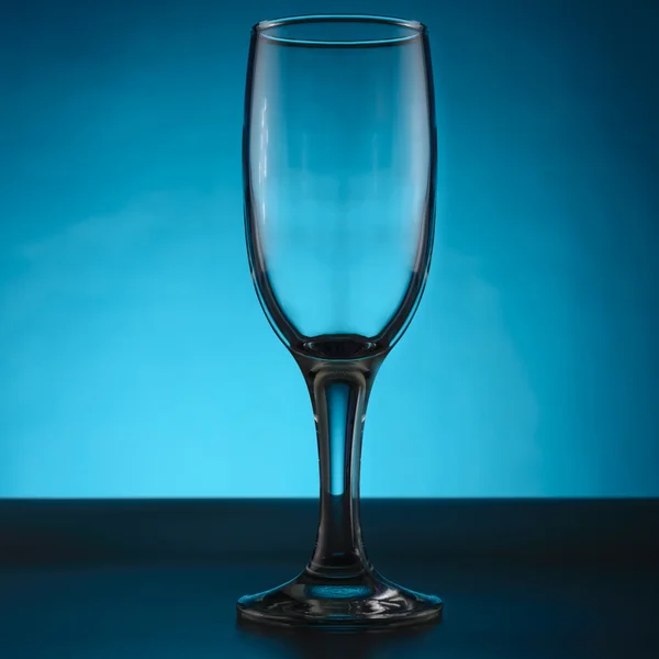 Leeres Champagnerglas isoliert auf blau — Stockfoto