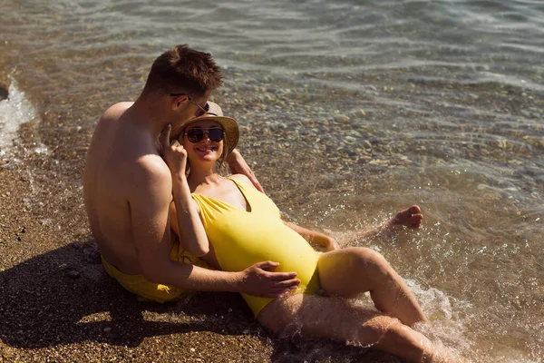 Jovem Casal Grávida Sorridente Está Sentado Junto Oceano Relaxando — Fotografia de Stock